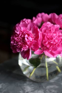 Pembe peonies bir cam vazo yuvarlak