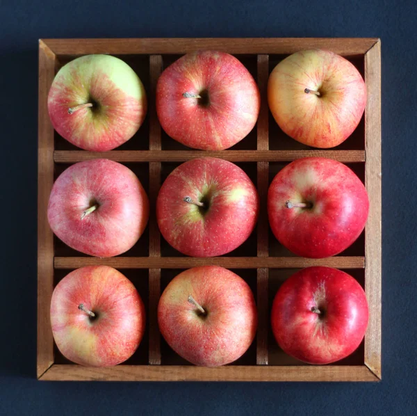 Red apples in a wooden box with cells