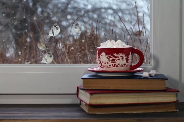 Bir pencere pervazına üzerinde kırmızı Noel kupa