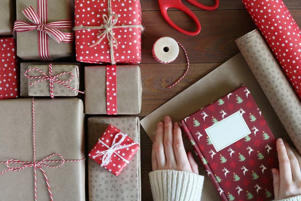 Mãos femininas embala o livro de Natal em papel — Fotografia de Stock