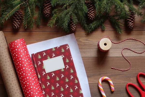 ギフトの紙で木製テーブルの上のクリスマス本の梱包 — ストック写真