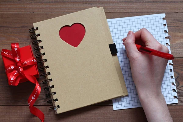 Жіноча Рука Ручкою Робить Нотатки Аркуші Паперу Ноутбука Червоним Серцем — стокове фото