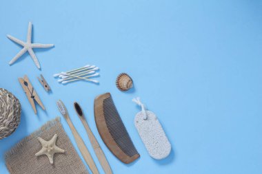 Eko-yaşam kavramı. Bambu diş fırçaları, ahşap saç fırçası, mavi arka planda tahta kulak çubukları. Sıfır plastik kavram