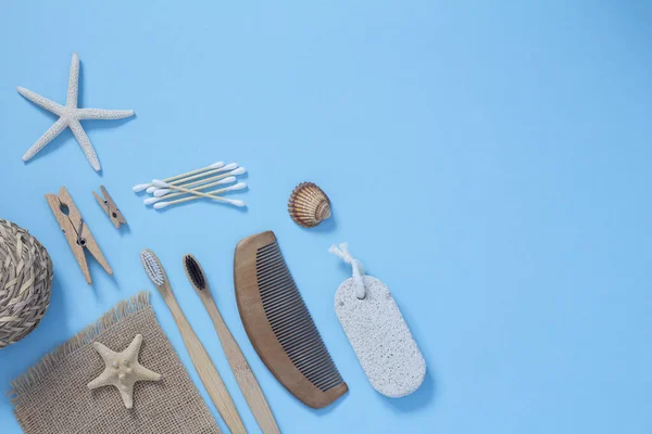 Eco living concept. Bamboo toothbrushes, wooden hairbrush, wooden ear sticks on a blue background top view. Zero plastic concept