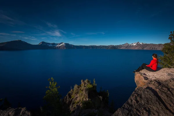 Mujer sentada al borde de un acantilado mirando el cráter Lake Oreg —  Fotos de Stock