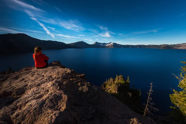 Mujer sentada al borde de un acantilado mirando el cráter Lake Oreg —  Fotos de Stock