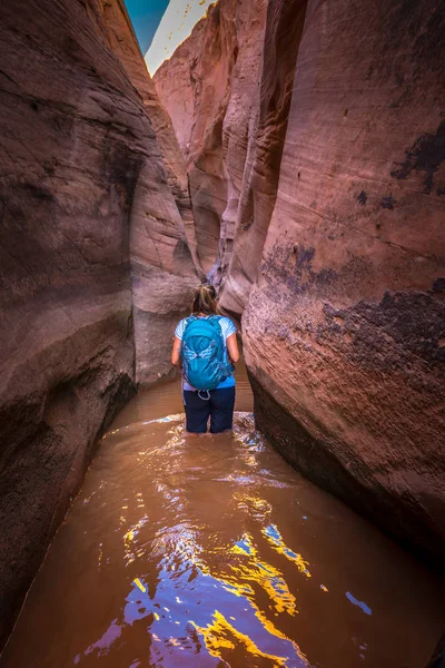 Backpacker dziewczyna w wodzie Utah Zebra Slot Canyon Escalante — Zdjęcie stockowe