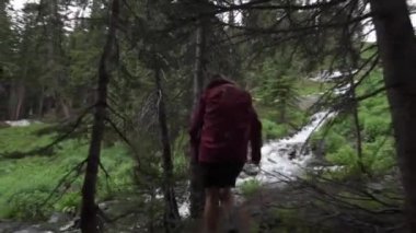 Göl Isabelle yakınındaki basamaklı creek Colorado kız Backpacker hiking bakar 