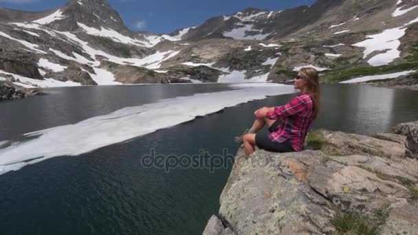 Touristin in farbenfrohem Wandermädchen ruht am blauen See — Stockvideo