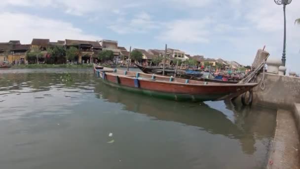 Рыбацкие лодки на реке Чу Бон со старыми жёлтыми зданиями в Хойане Вьетнам — стоковое видео