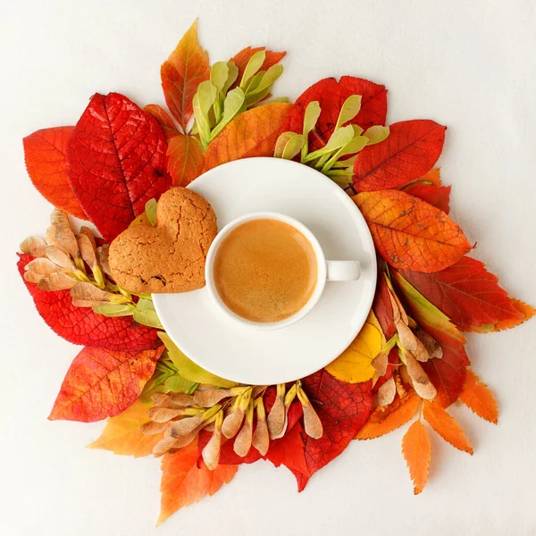Cup of coffee and autumn leaves wreath on a white table, Seasonal warming flatlay concept of menu - cafe, coffeehouse. Bright fall postcard