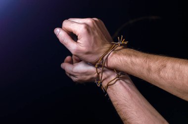 Paslı dikenli tellere sarılı koyu bir arka planda