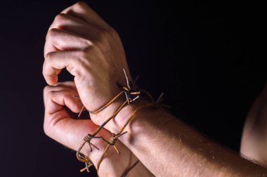 Paslı dikenli tellere sarılı koyu bir arka planda