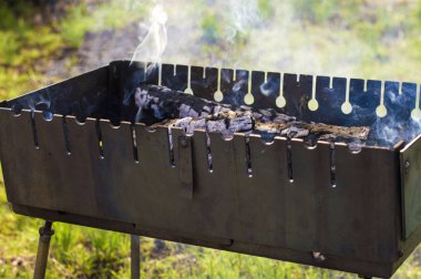 Yeşil otların arka planında ısıtmalı barbekü.