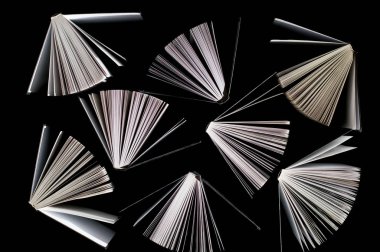 Siyah arkaplan üzerine yarı açık kitapların üst görünümü