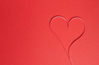 heart of paper strips on a red background