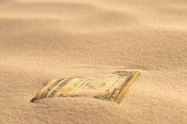 banknote covered with sand
