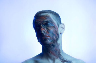 portrait of a guy, his face is drenched in dark colors