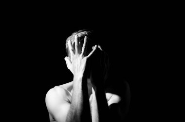 Bir adamın dramatik portresi, elleri suratında.