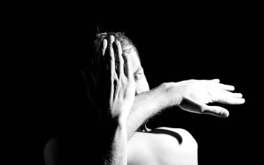 Bir adamın dramatik portresi, elleri suratında.