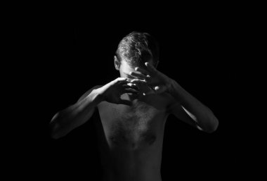 Bir adamın dramatik portresi, elleri suratında.