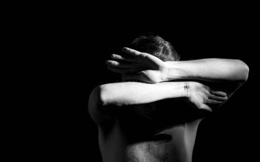 Bir adamın dramatik portresi, elleri suratında.