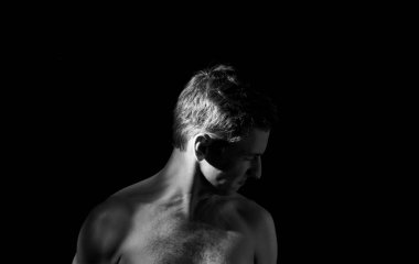 Çarpık bir pozdaki bir adamın dramatik portresi.