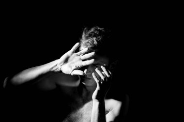 Bir adamın dramatik portresi, elleri suratında.