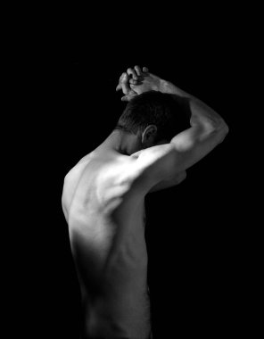 Elleri başının arkasında olan bir adamın dramatik portresi.