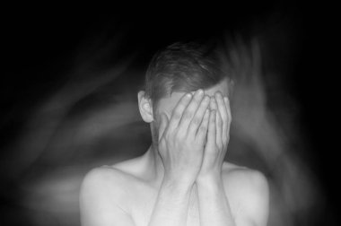 Bir adamın portresi, elleriyle yüzünü kapatıyor.