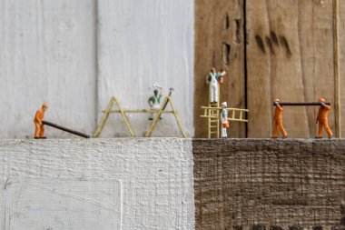 Endüstriyel sektörde çalışan minyatür şahıslar - İnşaat ve boyama işçilerinin konseptini seçici bir odak ile kapatın.