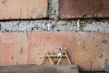 Endüstriyel sektörde çalışan minyatür figür - Temizlik ve boyama işçilerinin seçici odaklı takım çalışması kavramını kapat.