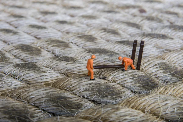 Endüstriyel sektörde çalışan minyatür figür - İp yüzeyi üzerine seçici odaklı inşaat işçileri takım çalışması kavramını kapat.