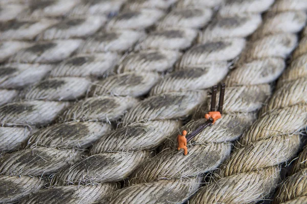 Endüstriyel sektörde çalışan minyatür figür - İp yüzeyi üzerine seçici odaklı inşaat işçileri takım çalışması kavramını kapat.