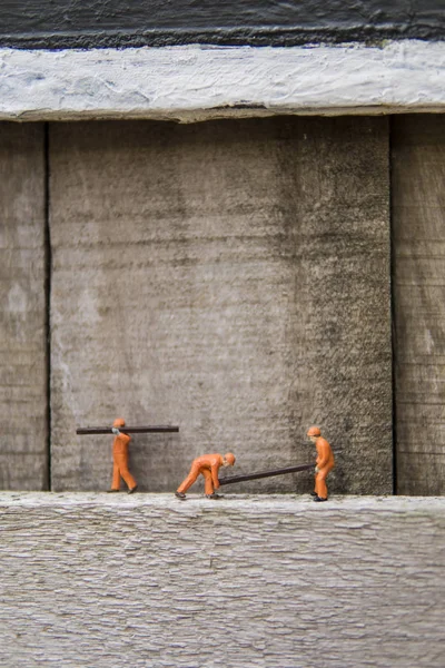 Endüstriyel sektörde çalışan minyatür figür - İnşaat işçilerinin seçici odaklı takım çalışması kavramını kapat.