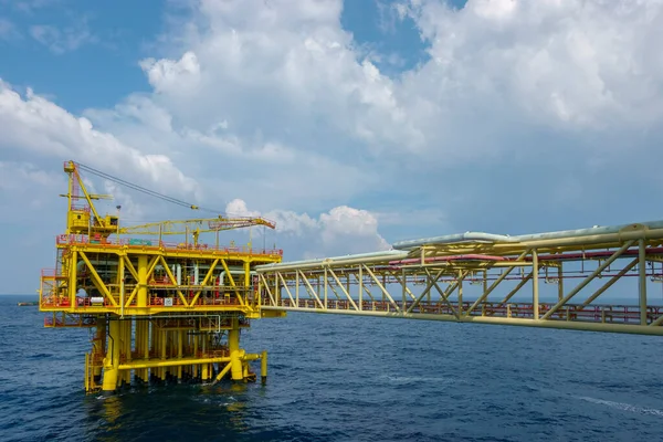 Oil and gas industry. A yellow well head platform complete with safety device and facilities in the middle of the sea.