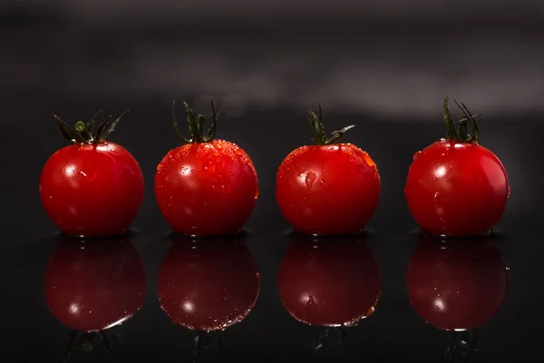 Tomaten auf schwarzem Hintergrund, Wassertropfen, Spiegel — Stockfoto