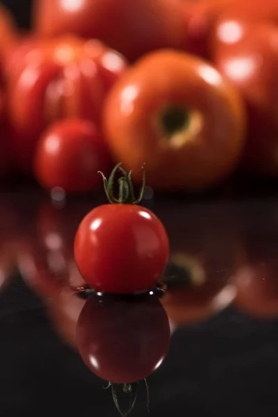 Tomaten auf schwarzem Hintergrund, Wassertropfen, Spiegel — Stockfoto