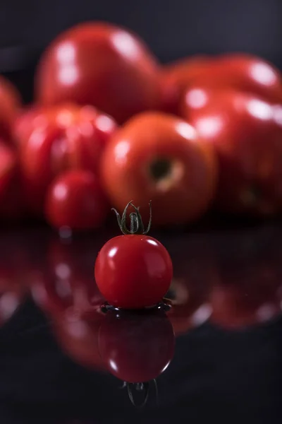 Tomaten auf schwarzem Hintergrund, Wassertropfen, Spiegel — Stockfoto