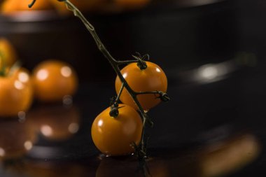  Siyah zemin üzerine sarı domates, su damlası, ayna