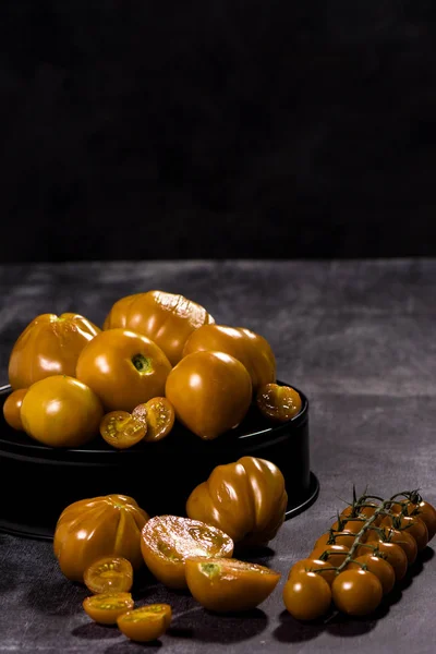 Gelbe Tomaten Zusammensetzung auf schwarzem Hintergrund — Stockfoto