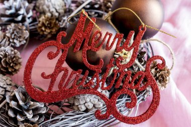 Parlak kırmızı mutlu Noeller el yapımı çelenk üzerinde