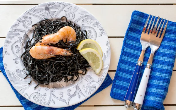Shrimps with black seaweed and slices of lemon — Stock Photo, Image