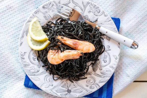 Shrimps with black seaweed and slices of lemon — Stock Photo, Image