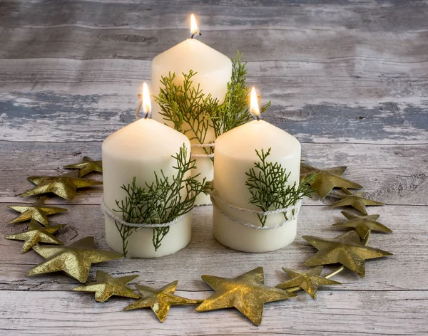 Still life of three candles burning with green branches — Stock Photo, Image