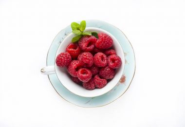 Beyaz arka plan üzerine bir fincan taze frambuaz