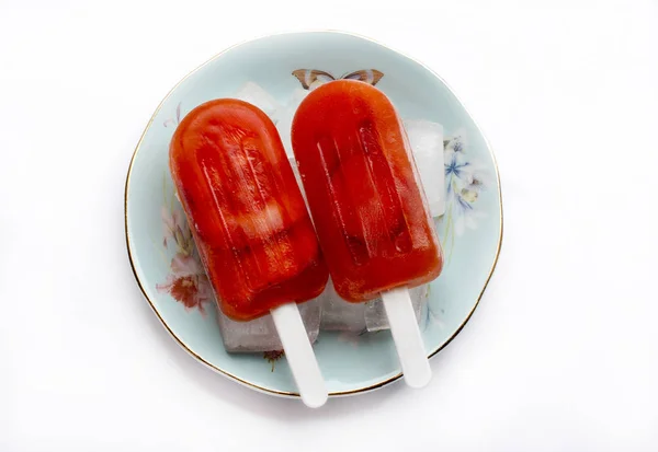 Picolés de morango Em uma chapa com gelo no fundo branco — Fotografia de Stock