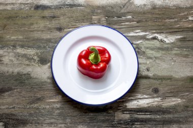 Taze kırmızı biber kesme ve rustik bir tablo bir tabağa yerleştirilmiş,