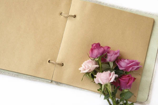 Bukett rosor på öppna anteckningsboken — Stockfoto