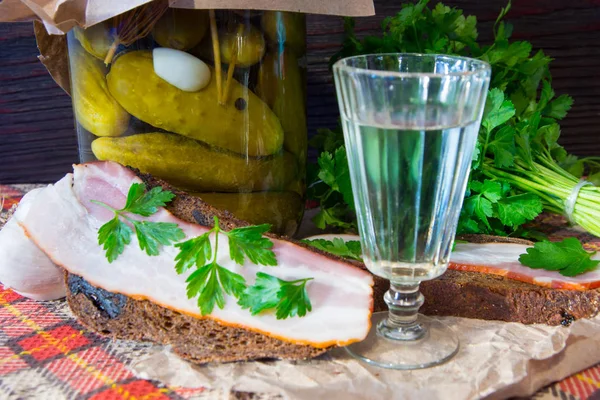 Traditional Ukrainian and Russian appetizer when dining. Food when drinking alcohol. Vodka and sandwiches with bacon, garlic and pickles. — Stock Image Traditional Ukrainian and Russian appetizer when dining. Food when drinking alcohol. Vodka and sandwiches with bacon, garlic and pickles. Stock Image